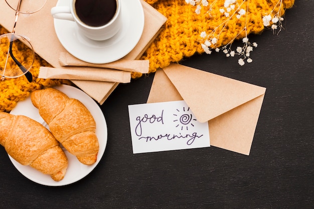 Foto gratuita croissants y café con tarjeta de felicitación.