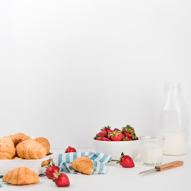 Foto gratuita croissants caseros con fresas en la mesa