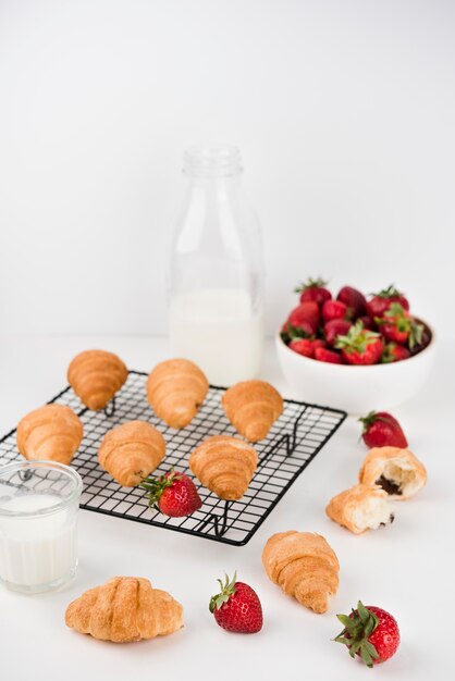 Foto gratuita croissants caseros con fresas en la mesa