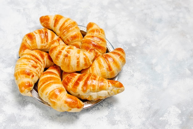 Croissants caseros sabrosos frescos en blanco grisáceo. Pastelería francesa