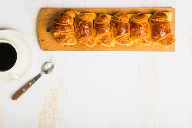 Croissants cerca de café y cuchara