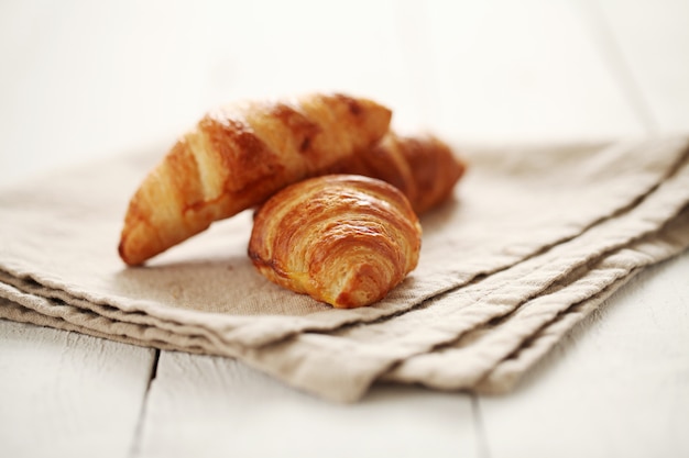 Croissants franceses frescos sobre un mantel