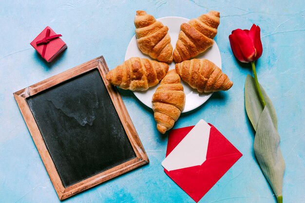 Croissants en placa con pizarra en blanco