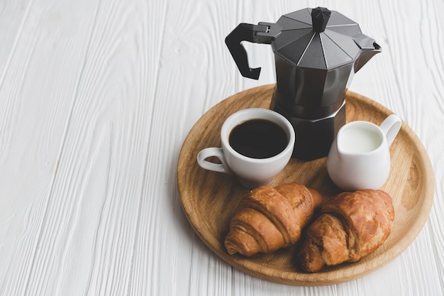 Foto gratuita croissants recién hechos y café en la bandeja