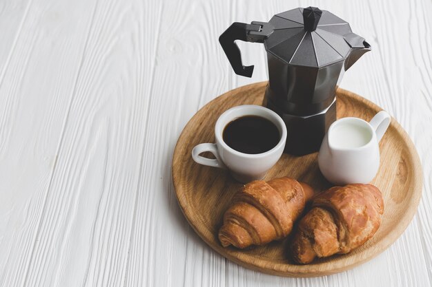 Croissants recién hechos y café en la bandeja