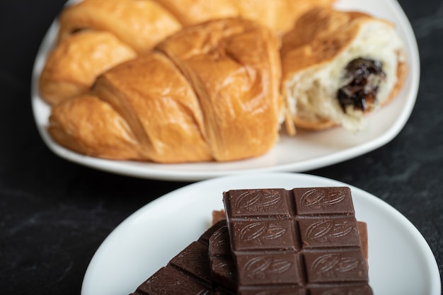 Croissants con relleno de chocolate sobre una superficie oscura.