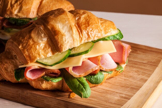 Croissants sándwiches en la tabla de cortar de madera