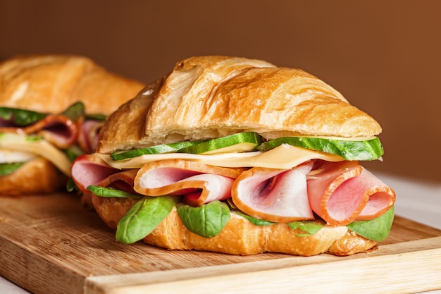 Foto gratuita croissants sándwiches en la tabla de cortar de madera