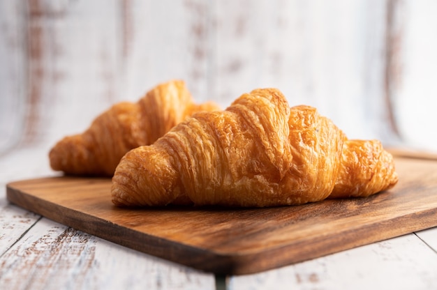 Foto gratuita croissants en una tabla para cortar madera.