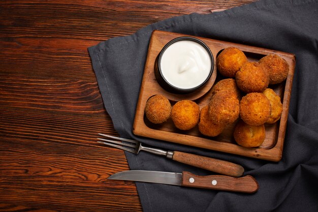 Croquetas de comida deliciosa en tablero de madera