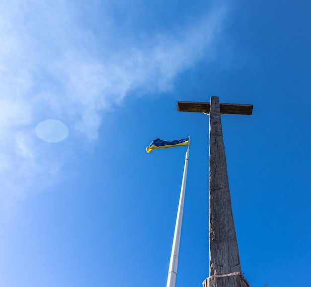 La crucifixión de jesucristo y la bandera de ucrania contra el cielo azul