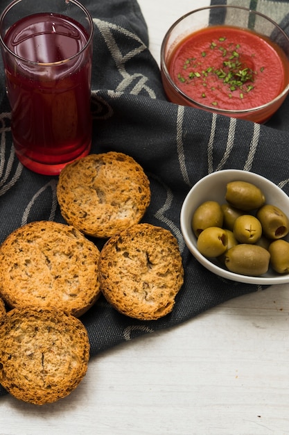 Crutones y aceitunas cerca de la salsa y la bebida