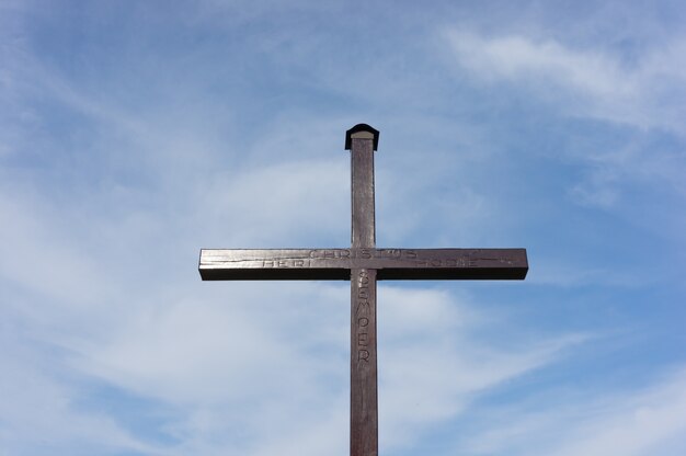 Cruz cristiana de madera bajo un cielo nublado