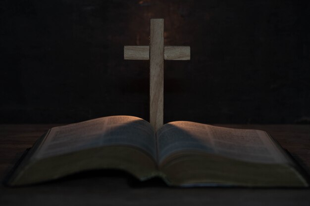 Cruz y Santa Biblia en mesa de madera