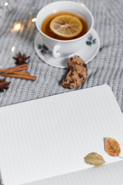 Cuaderno abierto cerca de la taza de té