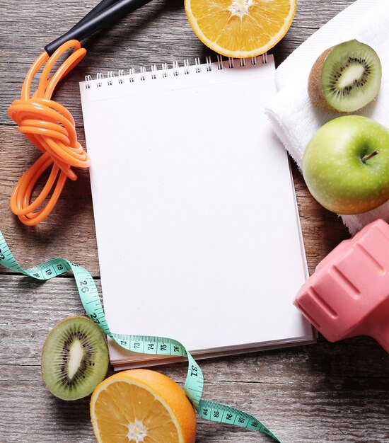 Un cuaderno y alimentos saludables a un lado