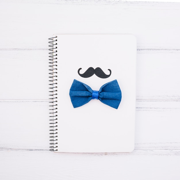 Cuaderno con bigote decorativo y pajarita.