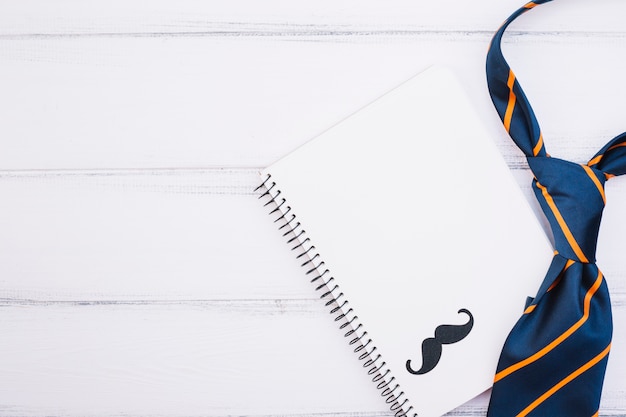 Cuaderno con bigote ornamental y corbata.