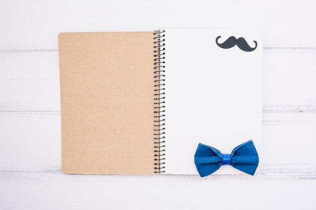Cuaderno con bigote ornamental y pajarita.