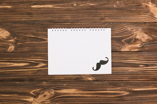 Cuaderno y bigote ornamental.