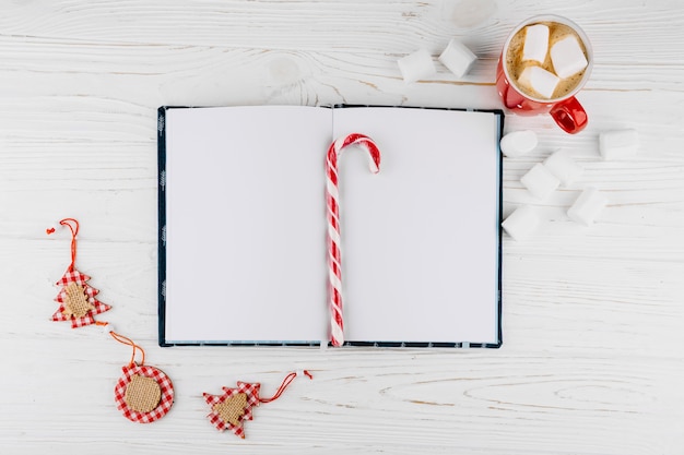 Cuaderno en blanco con bastón de caramelo en la mesa