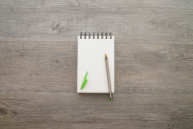 Cuaderno en blanco con bolígrafo sobre superficie de madera