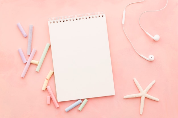 Cuaderno en blanco con estrella de mar y auriculares