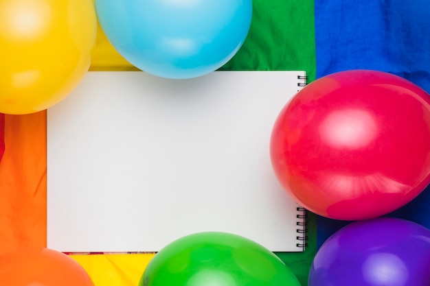 Cuaderno en blanco y globos de colores.