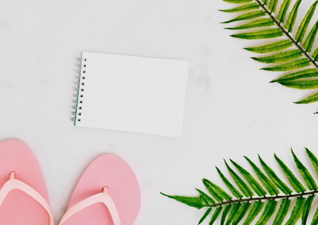 Cuaderno en blanco con hoja de palmera tropical