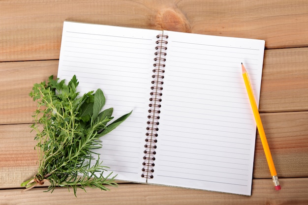 Foto gratuita cuaderno en blanco con un manojo de hierbas