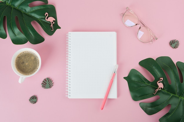 Cuaderno en blanco con la pluma en la mesa de color rosa