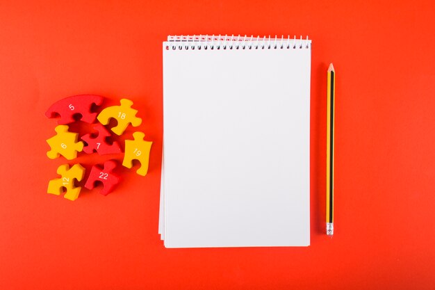 Cuaderno en blanco con rompecabezas en la mesa