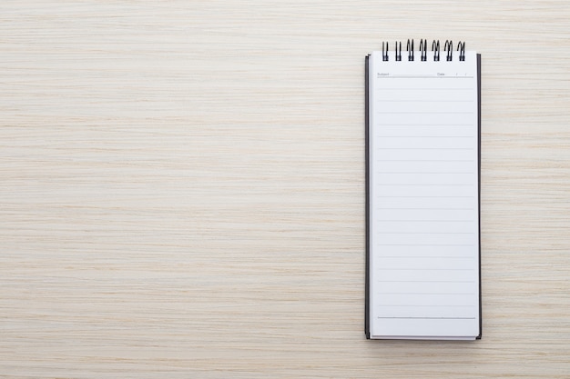 Cuaderno en blanco sobre mesa de madera