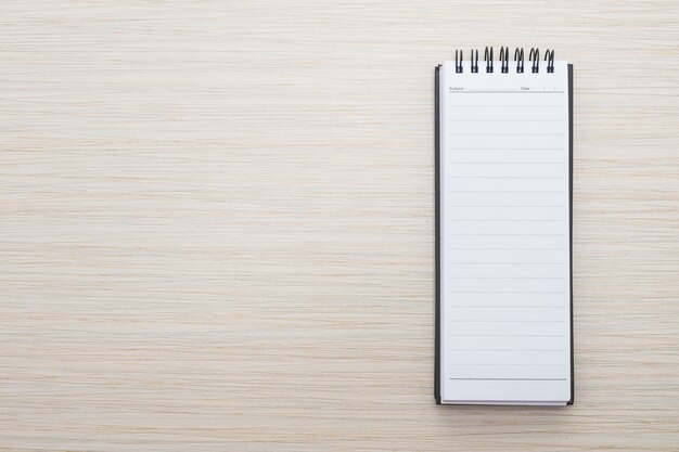 Cuaderno en blanco sobre mesa de madera