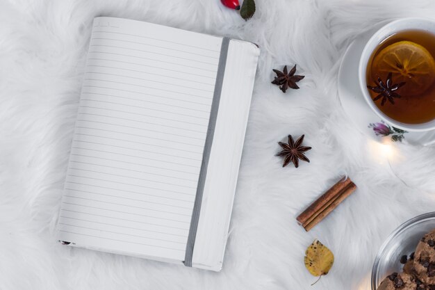 Cuaderno en blanco con taza de té en cuadros