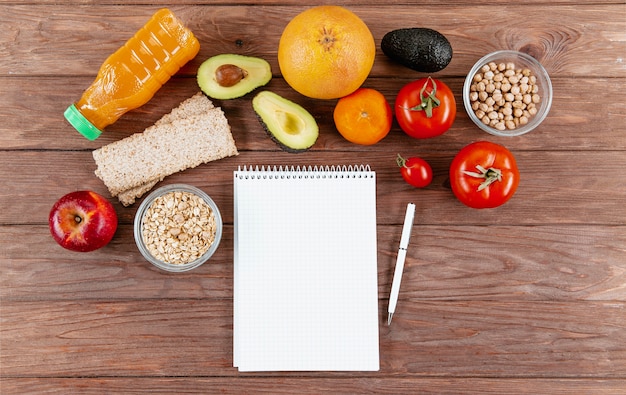 Cuaderno con bolígrafo y verduras