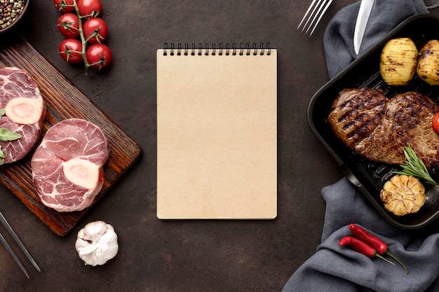 Cuaderno y carne preparada para cocinar