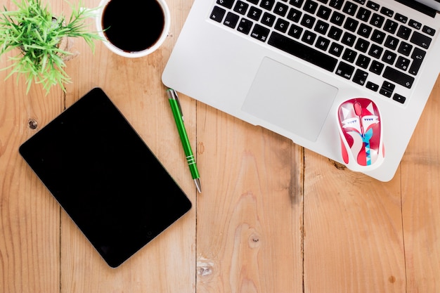 Foto gratuita cuaderno cerca de café y portátil en la tabla de madera