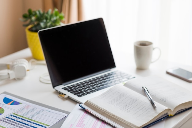 Cuaderno cerca de la computadora portátil en la mesa