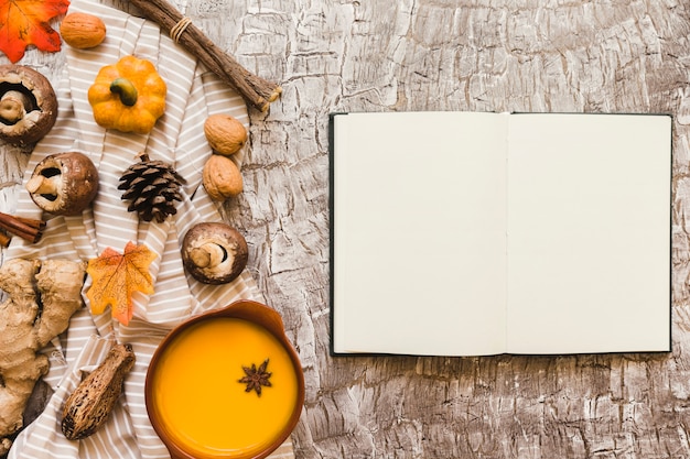 Foto gratuita cuaderno cerca de sopa y símbolos de otoño