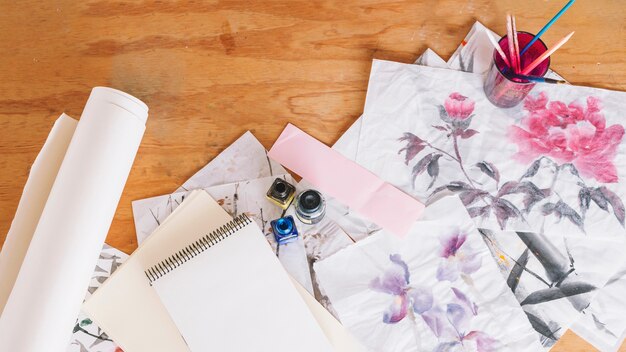 Cuaderno cerca de tinta e imágenes