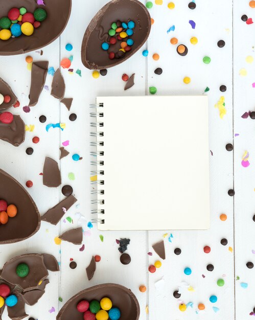 Cuaderno con chocolate abierto, huevos de Pascua y dulces.