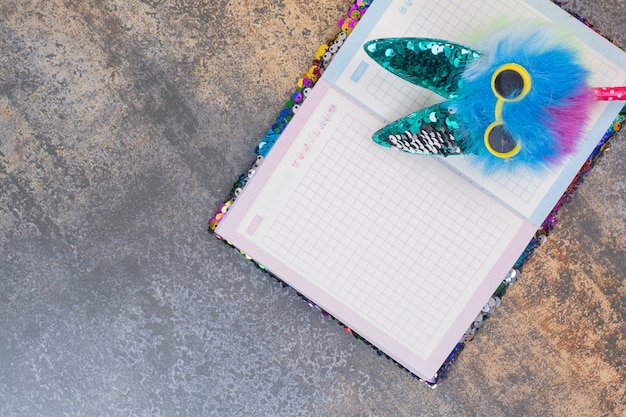 Foto gratuita cuaderno colorido con bolígrafo en espacio de mármol