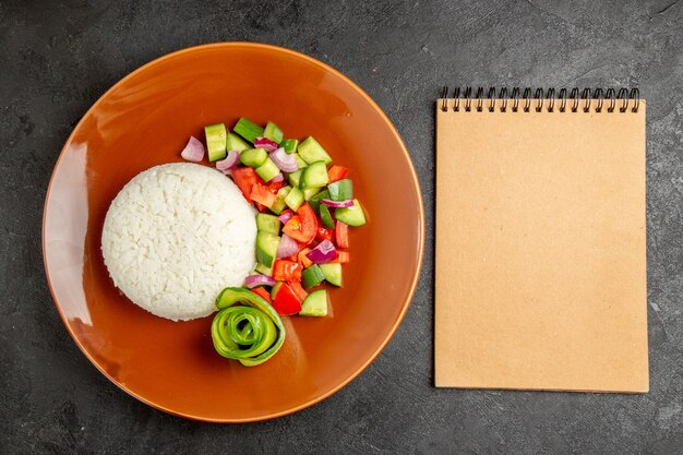 Cuaderno y comida saludable fácil sobre fondo oscuro