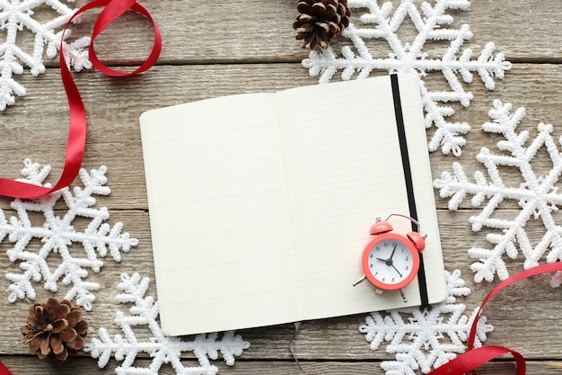 Cuaderno y despertador en copos de nieve