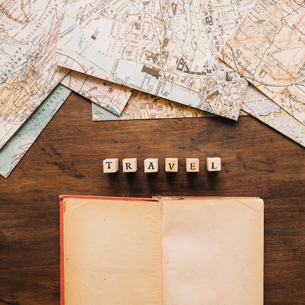 Cuaderno y escritura de viaje cerca de los mapas