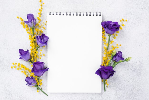 Cuaderno con flores florecientes al lado