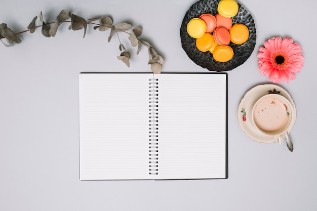 Cuaderno con galletas y flores en la mesa