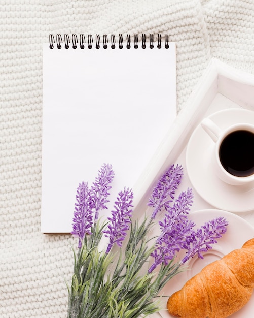 Cuaderno junto a la bandeja con desayuno