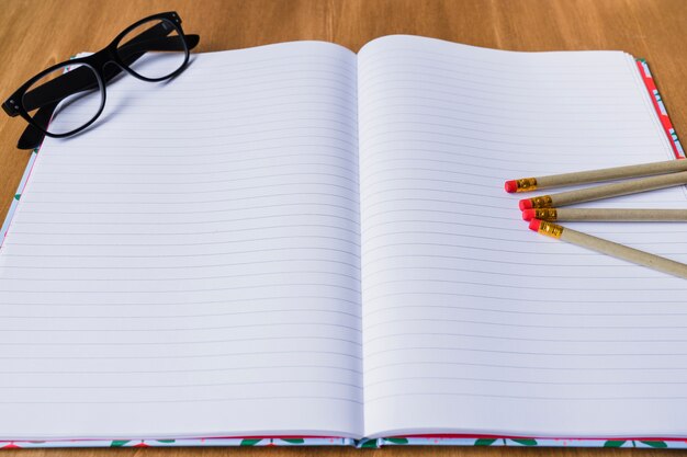 Cuaderno, lápices y gafas